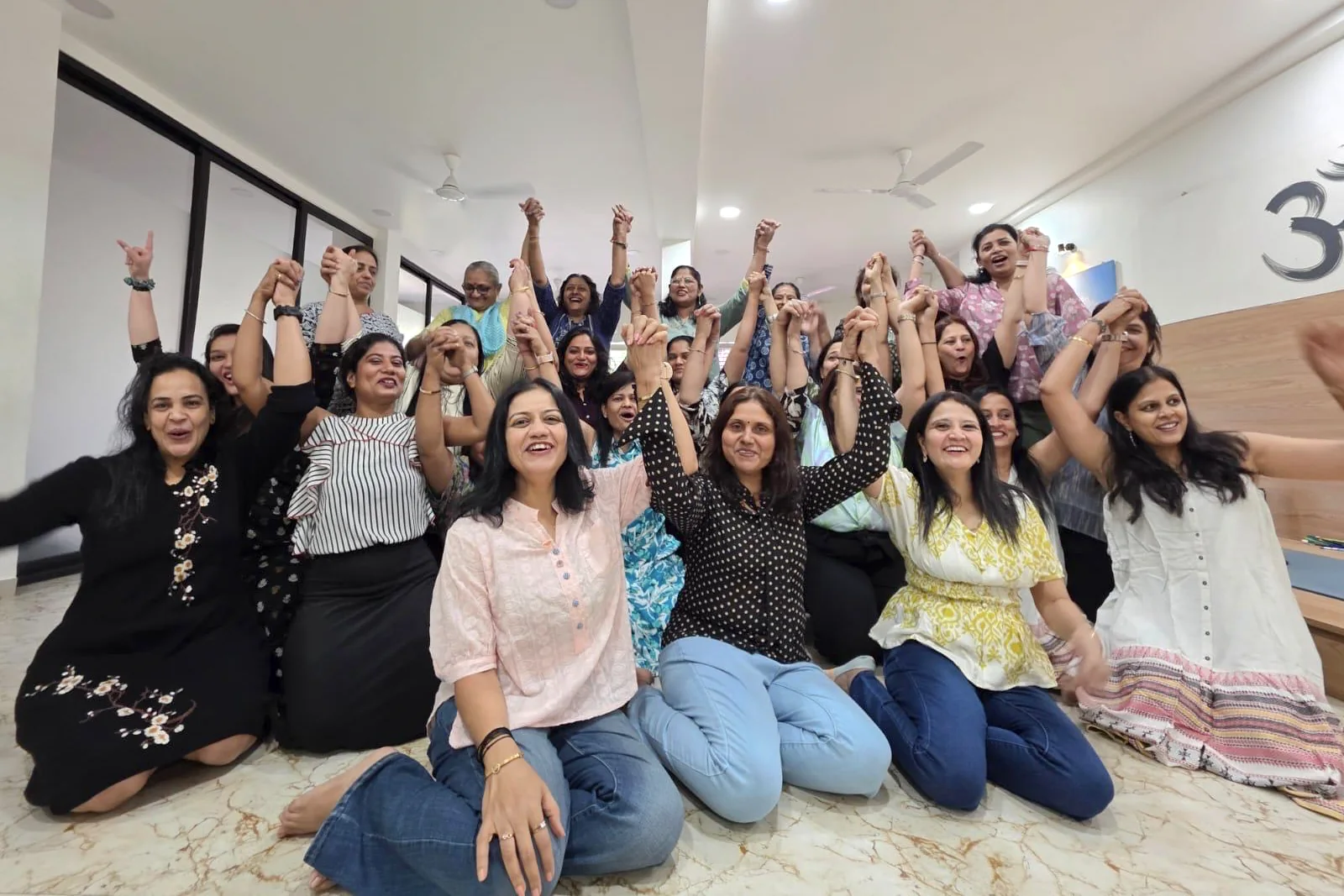 Students celebrating together with raised hands at Shraddha Yoga Space